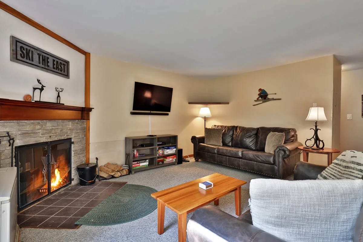 A bright and airy living area featuring a comfortable sofa, coffee table, and fireplace, with the TV positioned for easy viewing. The arrangement is ideal for both quiet relaxation and lively gatherings, echoing the section's emphasis on connection and shared experiences.